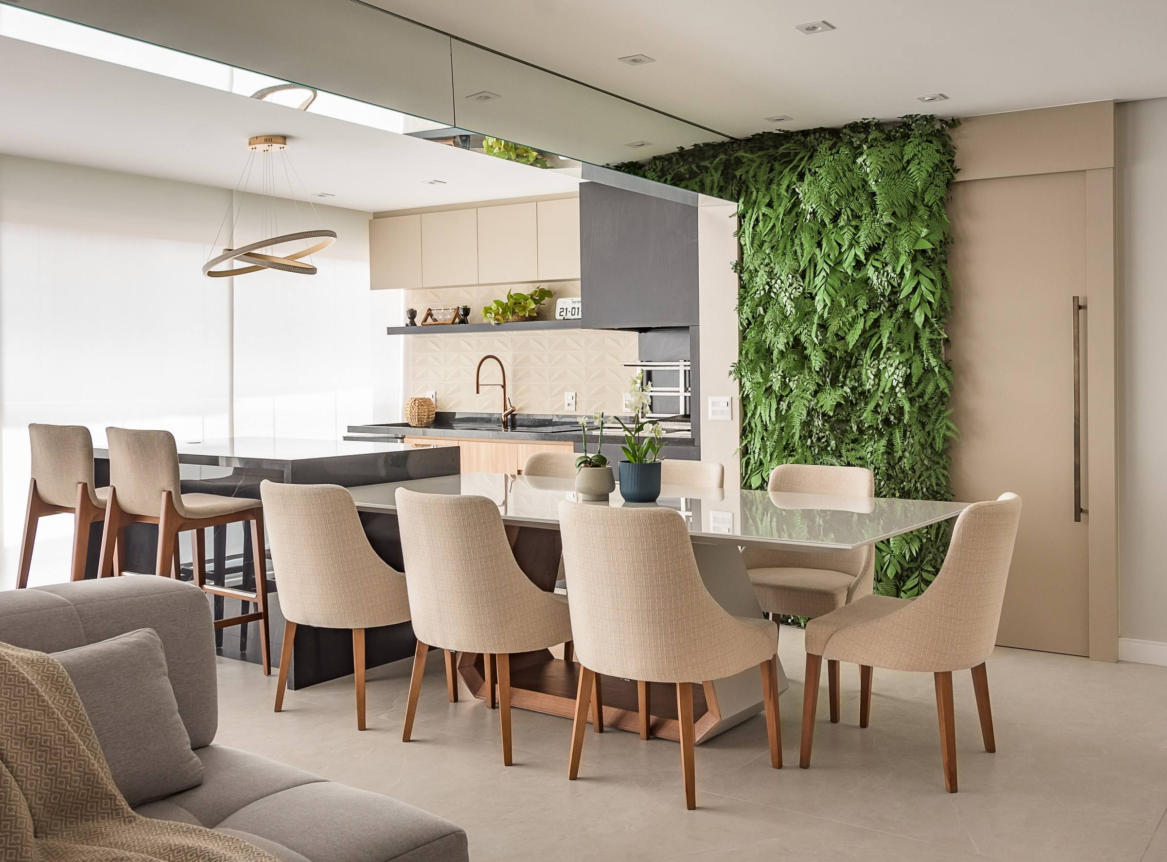 Sala integrada à cozinha, com parede de vegetação natural ao fundo